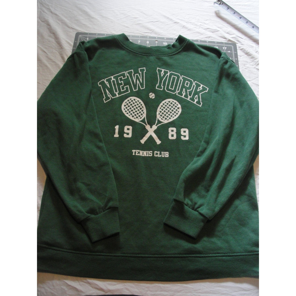 Green crewneck sweatshirt featuring a "New York 1989 Tennis Club" graphic.